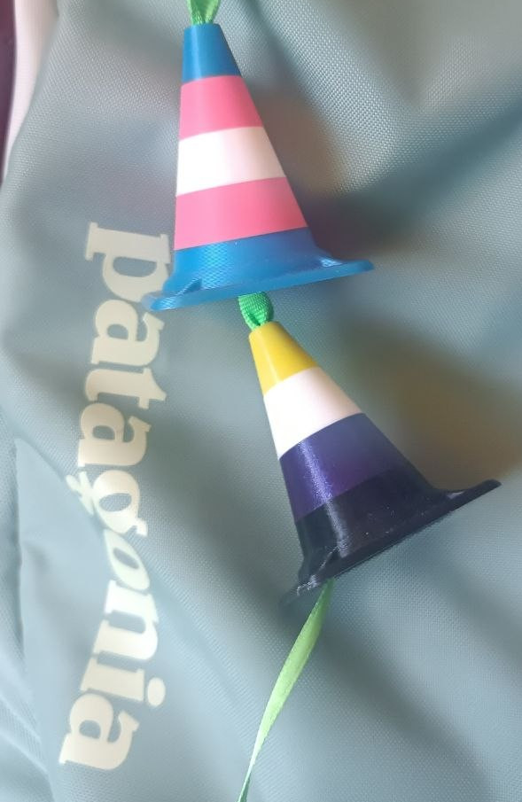 a photo of the backpack with 2 cones on a ribbon